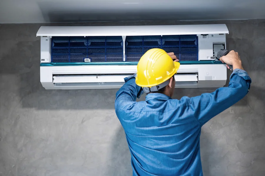 Técnico instalando um ar-condicionado split na parede